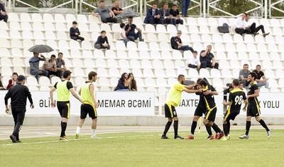 Azərbaycanlı məşqçi uşağı pencəyinin altında yağışdan qorudu - FOTOLAR