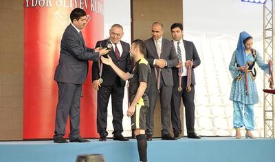 Azərbaycanlı məşqçi uşağı pencəyinin altında yağışdan qorudu - FOTOLAR