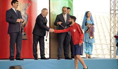 Azərbaycanlı məşqçi uşağı pencəyinin altında yağışdan qorudu - FOTOLAR