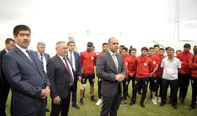 Azərbaycanlı məşqçi uşağı pencəyinin altında yağışdan qorudu - FOTOLAR