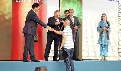 Azərbaycanlı məşqçi uşağı pencəyinin altında yağışdan qorudu - FOTOLAR