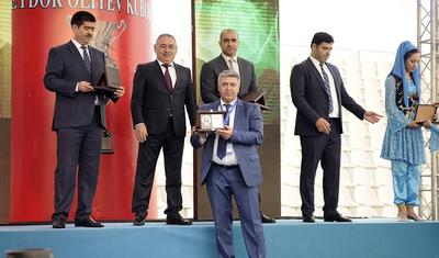 Azərbaycanlı məşqçi uşağı pencəyinin altında yağışdan qorudu - FOTOLAR