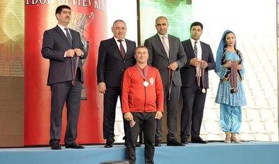 Azərbaycanlı məşqçi uşağı pencəyinin altında yağışdan qorudu - FOTOLAR