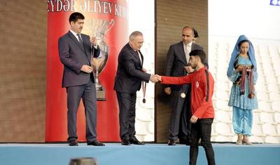Azərbaycanlı məşqçi uşağı pencəyinin altında yağışdan qorudu - FOTOLAR