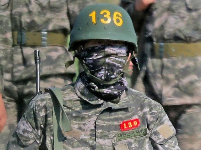 Başında dəbliqə, çiynində avtomat